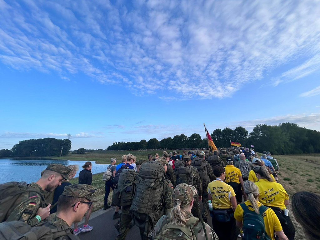 POV | The team following other walkers past a lake.